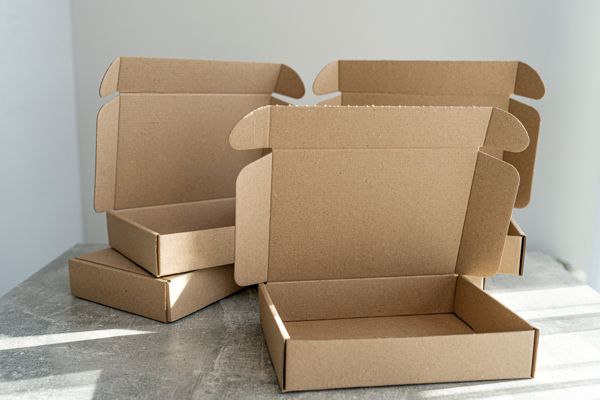 three-kraft-cardboard-boxes-with-open-lids-concrete-table